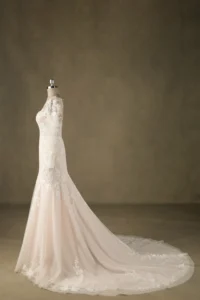 Mermaid-style wedding dress with intricate lace designs displayed on a mannequin against a plain background, highlighting craftsmanship.