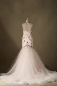 Back view of a strapless mermaid wedding dress on mannequin, featuring floral embroidery and a voluminous tulle skirt.