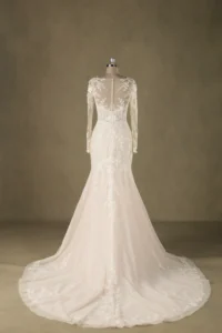 A mermaid wedding dress featuring a lace back with long sleeves and intricate floral detailing, displayed on a mannequin.