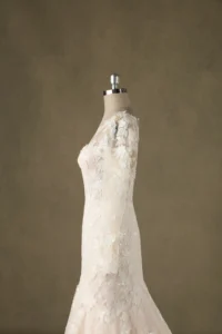 Side view of a lace mermaid wedding dress on a mannequin, showcasing intricate floral patterns and refined craftsmanship.