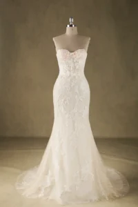 Strapless lace wedding dress with intricate floral embroidery displayed on a mannequin in a studio setting.