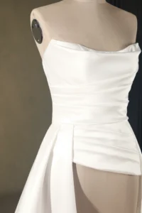 A stylish white wedding dress displayed elegantly on a mannequin, showcasing detail and craftsmanship from SisterBridal.