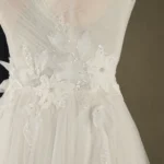 Close-up of a wedding dress featuring intricate floral embroidery and delicate sequins on a mannequin.