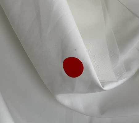 satin wedding dress surface showing visible oil stain during production quality check