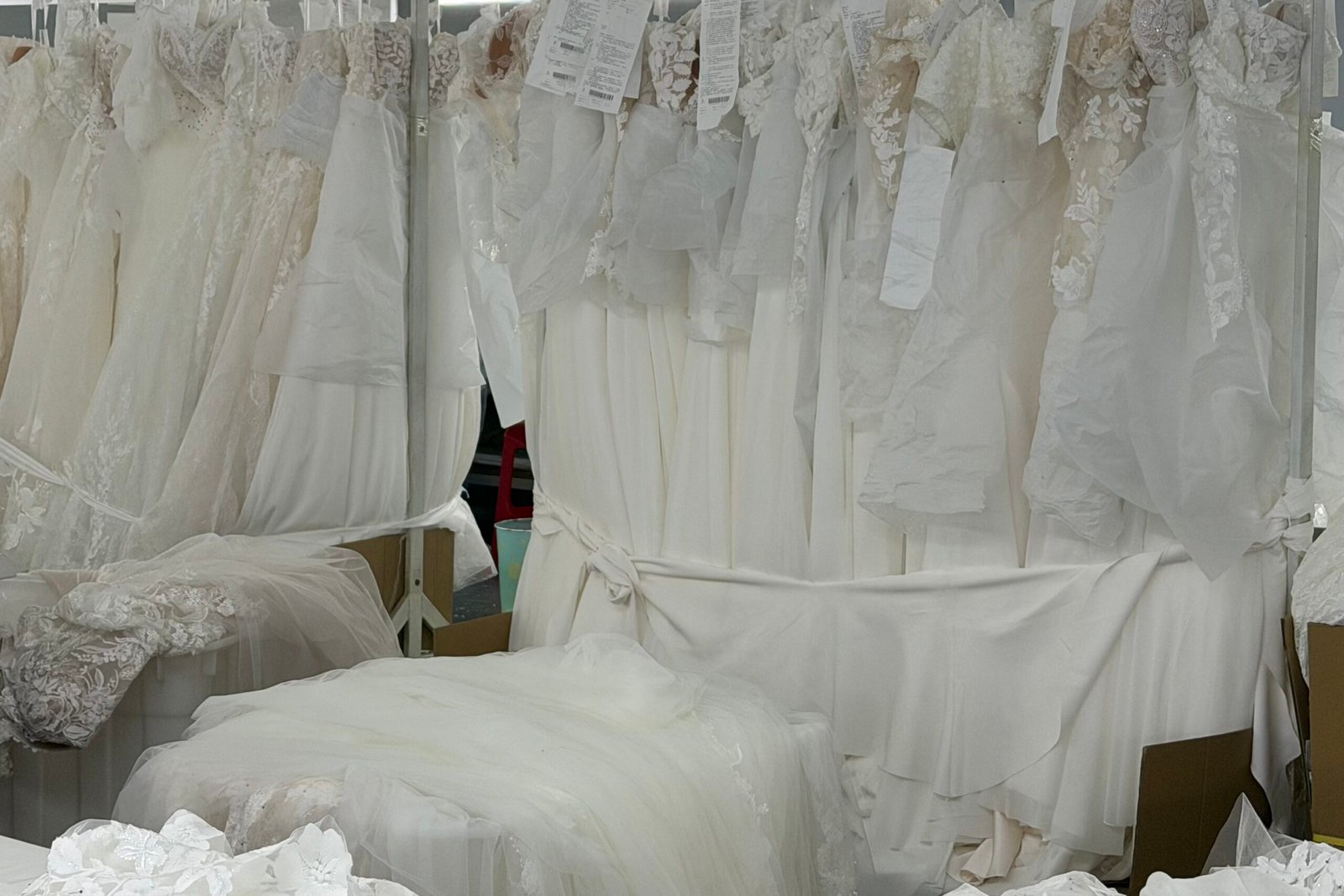 quality inspector examining satin wedding dress for oil and water stains before shipment