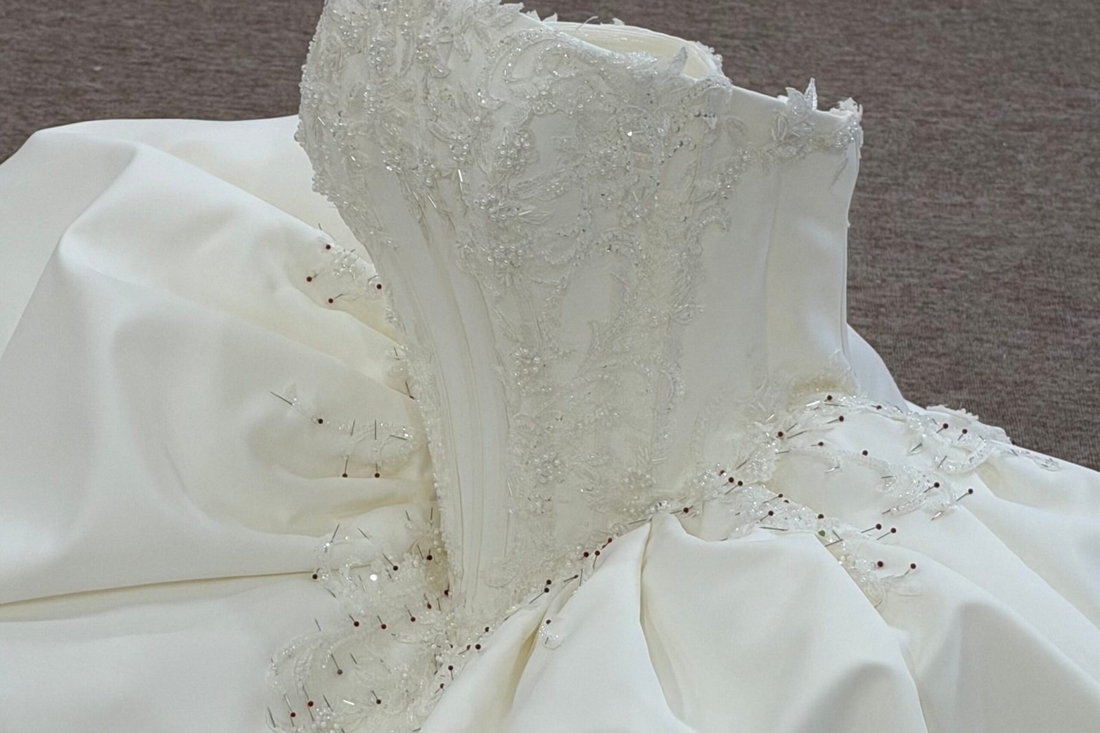 factory floor showing protective garment covers and clean handling procedures for satin wedding dresses